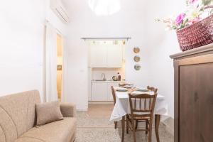 ein Wohnzimmer mit einem Tisch und einer Küche in der Unterkunft Appartamento con AC-wi-fi- centro a 7 min in Savona