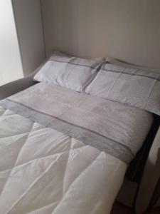 a white bed with a blanket on top of it at Mono-bijoux Albergian, ideale x2 in Turin