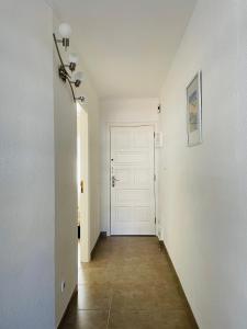pasillo con puerta blanca y suelo de baldosa en Apartamento Brisas del Mar, en San Miguel de Abona