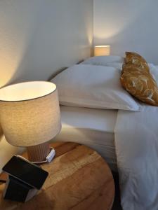 a bedroom with a bed and a lamp on a table at La Villa Baie du Marin in Le Marin