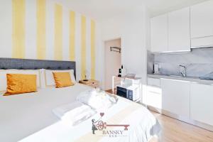 una camera da letto con un grande letto bianco con cuscini arancioni di Sunny Suite Nordic - Lugano City -By EasyLife Swiss a Lugano