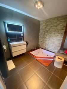 uma casa de banho com banheira no meio de um quarto em SKY one & two em Smržovka