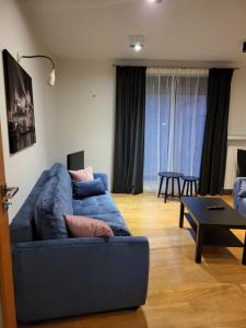 uma sala de estar com um sofá azul e uma mesa em AMBER APARTAMENt #127 em Cracóvia