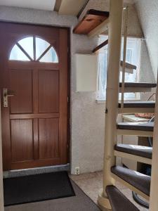a wooden door in a room with a spiral staircase at Finnhütte Tanne in Tanne