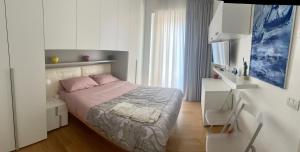 una camera bianca con un letto di Casa Florenzia a Porto San Giorgio