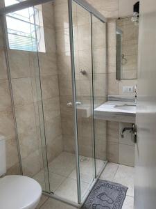 W łazience znajduje się prysznic, toaleta i umywalka. w obiekcie Pousada Guarujá w mieście Guarujá