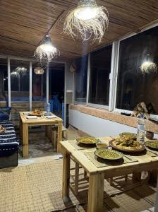 een patio met houten tafels en borden met eten erop bij Let Us Surf in Agadir