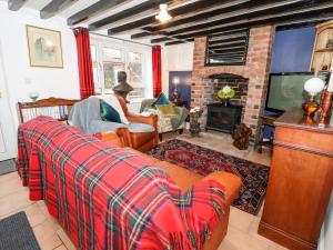a living room with a couch and a fireplace at Smithy Cottage in Wrexham