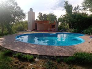 una piscina en un patio con una casa al fondo en Los chañares en San Javier