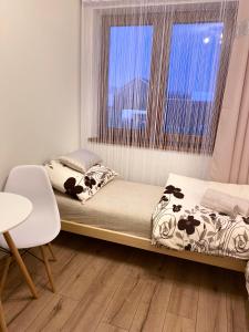 a small bed in a room with a window at Nowa Biała Apartament - domek na wyłączność in Nowa Biała