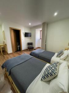 duas camas num quarto de hotel com televisão em Casa Dona Eufémia em Pinhão