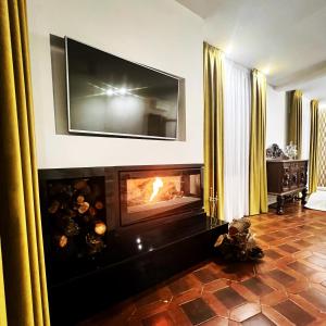 a living room with a fireplace with a tv above it at Tomé, casa de huéspedes in Orgaz