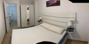 a white bedroom with a white bed with a headboard at Sant Vicent 35 in heart of Old town in Benidorm