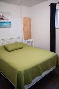 sypialnia z łóżkiem z zielonym kocem w obiekcie Chalet Le Marin à 5 minutes du centre ville w mieście Sainte-Flavie