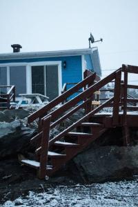 une maison avec un escalier en bois devant elle dans l'établissement Chalet Le Marin à 5 minutes du centre ville, à Sainte-Flavie