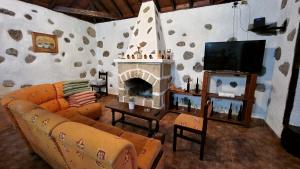 CASA TIO MANUEL في La Tierra del Trigo: غرفة معيشة مع أريكة ومدفأة
