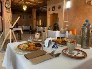 a table with plates of food on top of it at Berber Nomad Kasbah in Nkob