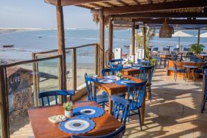 a restaurant with tables and chairs on the beach at Vila Maria Pousada in Jericoacoara
