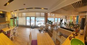 a restaurant with tables and chairs and a large window at Hotel Rivero A&S in Mostar