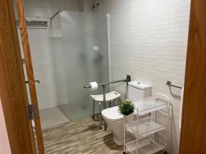 een badkamer met een toilet en een douche bij HOSTAL LA BATUTA in Mogente