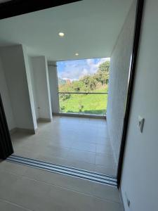 een lege kamer met uitzicht op een groen veld bij Cómodo Apartamento en Manizales in Manizales