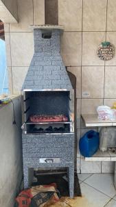 a kitchen with an oven with some food inside at Casa de praia in Itanhaém