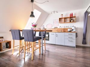 cocina y comedor con mesa y sillas en Smile, wunderschöne Wohnung direkt am Strand, en Harrislee