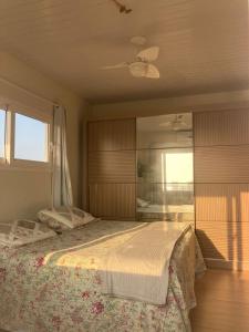 - une chambre avec un lit et un ventilateur de plafond dans l'établissement Apartamentob301 coliving bombinhas, à Bombinhas
