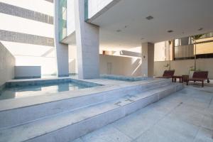 a swimming pool in the middle of a building at Acqua Prime Maceió Ponta Verde in Maceió