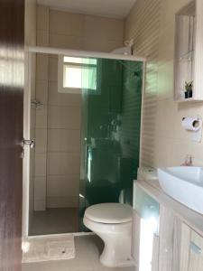 y baño con ducha, aseo y lavamanos. en Apartamentob301 coliving bombinhas, en Bombinhas