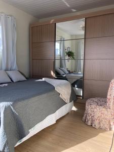1 dormitorio con 1 cama grande y 1 silla en Apartamentob301 coliving bombinhas, en Bombinhas