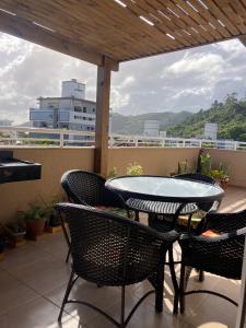 patio con mesa y sillas en el balcón en Apartamentob301 coliving bombinhas, en Bombinhas