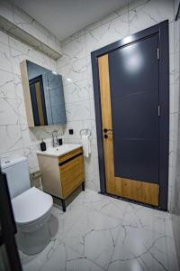 een badkamer met een toilet, een deur en een wastafel bij Uğur in Nilüfer