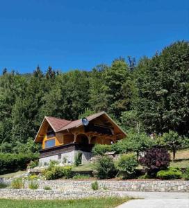 ein Haus auf einem Hügel mit Bäumen im Hintergrund in der Unterkunft Lunela estate with sauna in Cerklje na Gorenjskem