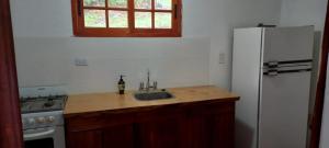 eine Küche mit einer Spüle und einem weißen Kühlschrank in der Unterkunft Los Cedros in Cordoba