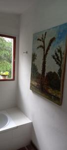 łazienka z obrazem na ścianie obok umywalki w obiekcie Los Cedros w Córdobie