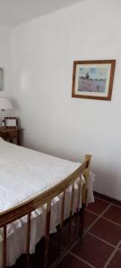 łóżko w pokoju ze zdjęciem na ścianie w obiekcie Los Cedros w Córdobie