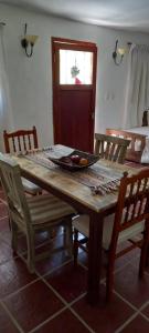 einen Holztisch mit Stühlen und eine Schale mit Obst darauf in der Unterkunft Los Cedros in Cordoba