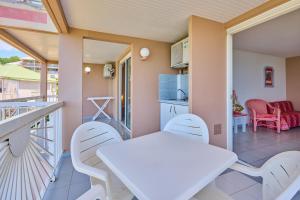 a balcony with a white table and chairs at Diamant Beach in Le Diamant