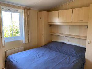 een kleine slaapkamer met een blauw bed erin bij chalet Klein Vechtdal in Ommen