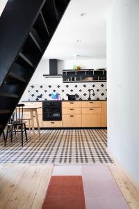 a kitchen with wooden cabinets and a table at Długa Design Apartment - Old Town in Gdańsk