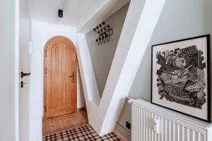 a hallway with a staircase with a wooden door at Długa Design Apartment - Old Town in Gdańsk