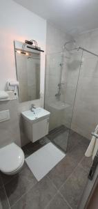 a bathroom with a shower and a toilet and a sink at Hotel Rivero A&S in Mostar