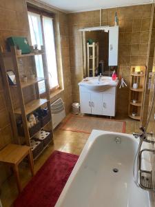 ein Badezimmer mit einer weißen Badewanne und einem Waschbecken in der Unterkunft in lak'ech - rooms in Chironico