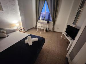 1 dormitorio con 1 cama, TV y escritorio en eXperience Rooms Valencia, en Valencia