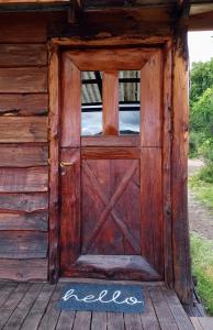 an open door of a wooden cabin with the word lodge written on it at Cabaña y Domos Ollagua con vista al lago in Cholila