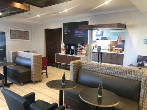 a restaurant with tables and chairs and a counter at Holiday Inn Express Hotel & Suites Woodward Hwy 270, an IHG Hotel in Woodward