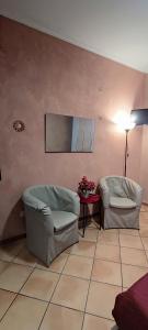 a living room with two chairs and a table at Casa Rosy.S in Pozzuoli
