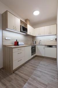 eine Küche mit weißen Schränken und einer Arbeitsplatte in der Unterkunft Apartmány Za Dvorem in Velké Pavlovice