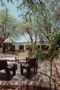 a picnic table and benches in a yard with trees at Vientos - La Yareta in San Pedro de Atacama
